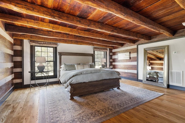 bedroom featuring beamed ceiling, wooden ceiling, and light hardwood / wood-style flooring