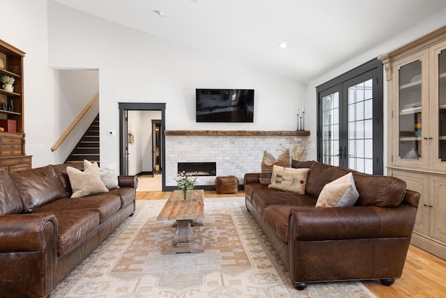 living room featuring french doors, light wood-type flooring, and lofted ceiling