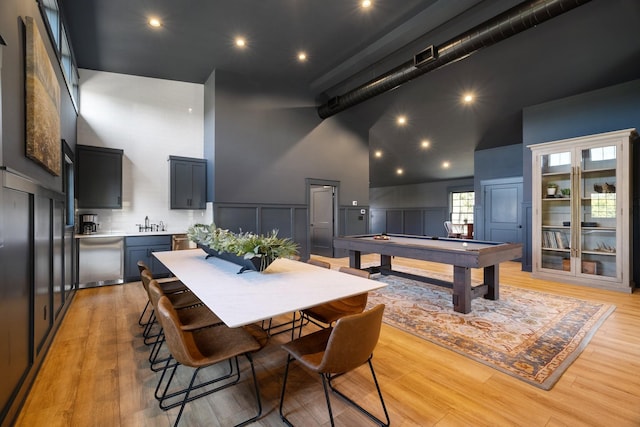 playroom with sink, a towering ceiling, light hardwood / wood-style floors, and pool table