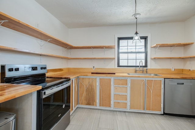 kitchen with appliances with stainless steel finishes, a textured ceiling, sink, pendant lighting, and butcher block counters