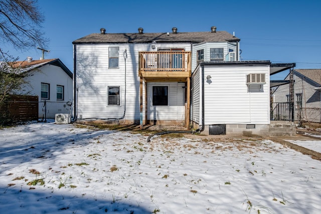 snow covered rear of property featuring a balcony