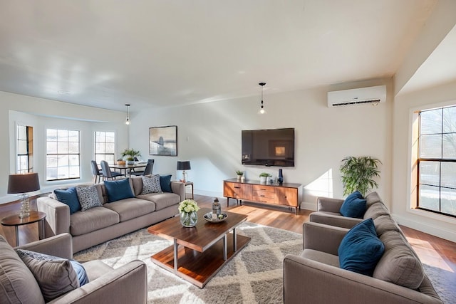 living room with an AC wall unit and light hardwood / wood-style floors