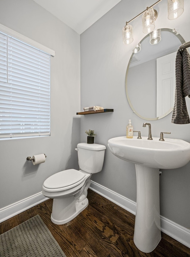 bathroom with hardwood / wood-style flooring, toilet, and sink