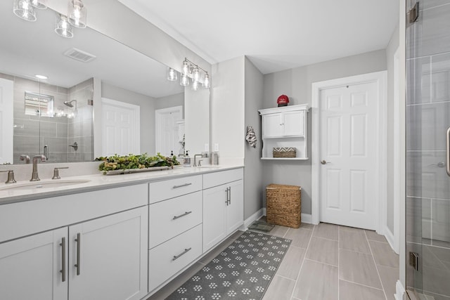 bathroom featuring tile patterned floors, a shower with door, and vanity