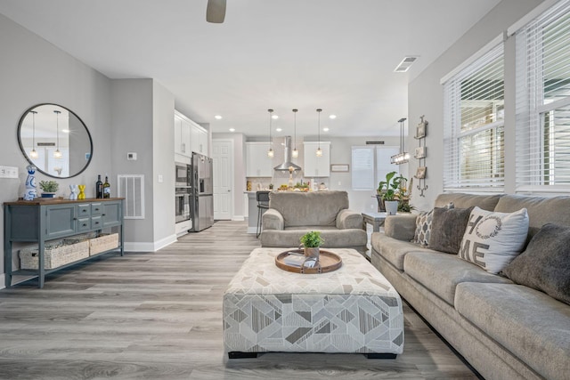 living room with ceiling fan and light wood-type flooring