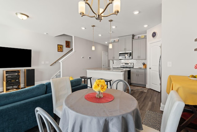 dining area featuring a chandelier, dark hardwood / wood-style floors, beverage cooler, and sink