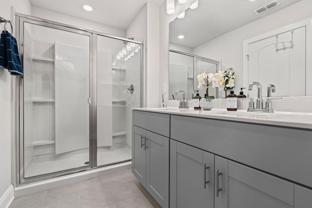 bathroom featuring tile patterned flooring, vanity, and a shower with shower door