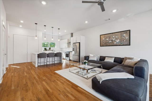 living room featuring ceiling fan and light hardwood / wood-style floors