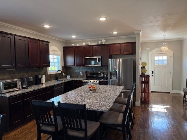 kitchen with stainless steel appliances, dark wood finished floors, a toaster, and a sink