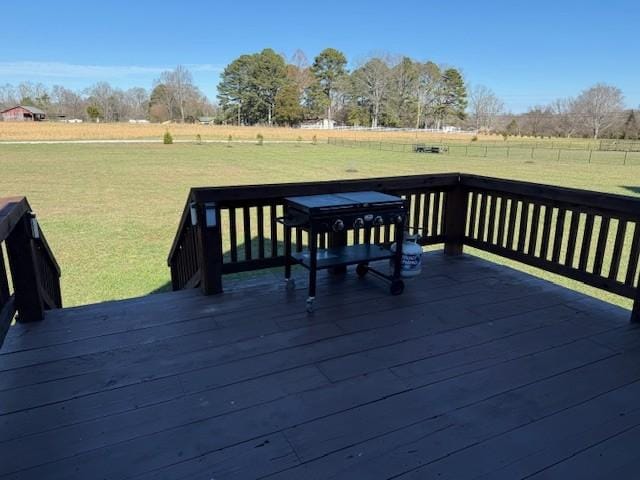 wooden deck with a rural view and a yard