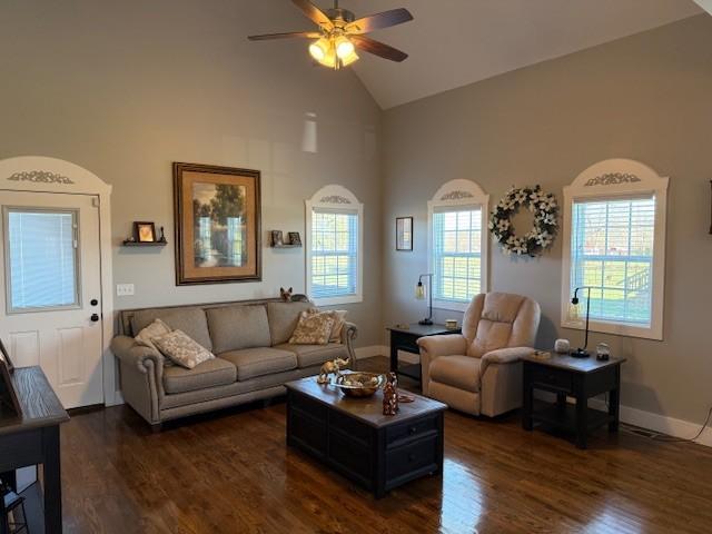 living room featuring high vaulted ceiling, ceiling fan, baseboards, and dark wood finished floors