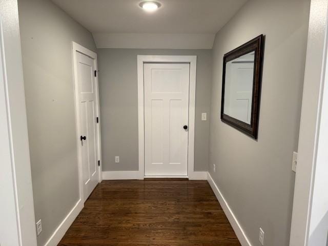 hallway featuring dark wood-style floors and baseboards