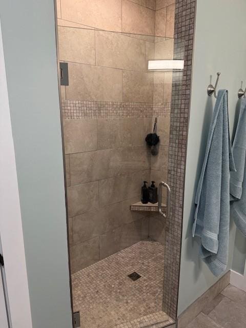 bathroom with toilet, a shower stall, and baseboards