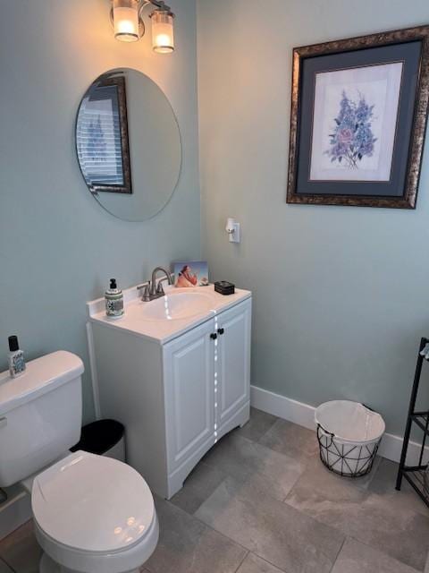 bathroom with vanity, toilet, and baseboards