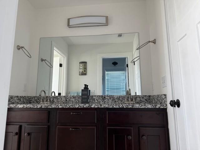 bathroom featuring a sink and double vanity