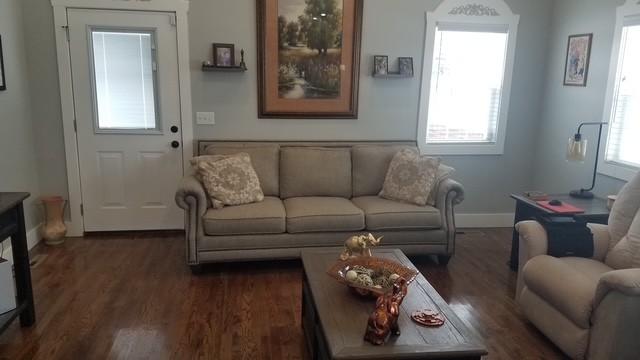 living room featuring plenty of natural light, dark wood finished floors, and baseboards