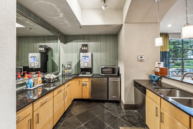 kitchen with sink, stainless steel appliances, kitchen peninsula, pendant lighting, and light brown cabinetry