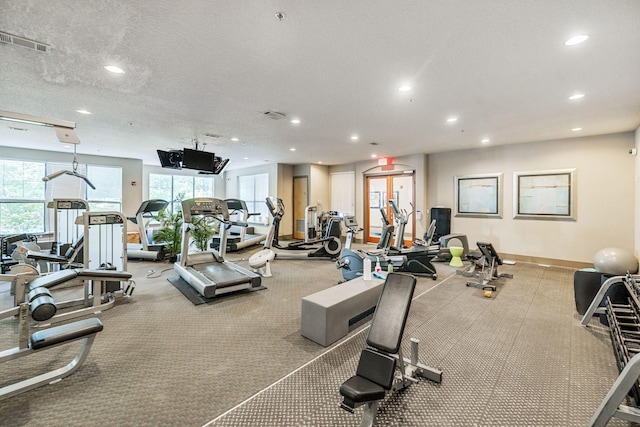 gym with plenty of natural light and a textured ceiling