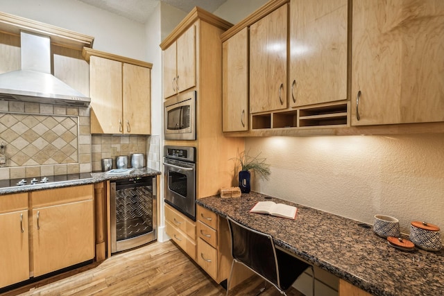 kitchen featuring decorative backsplash, appliances with stainless steel finishes, beverage cooler, wall chimney range hood, and light hardwood / wood-style floors