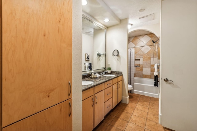 full bathroom with vanity, tile patterned flooring, toilet, shower / bathtub combination with curtain, and a textured ceiling