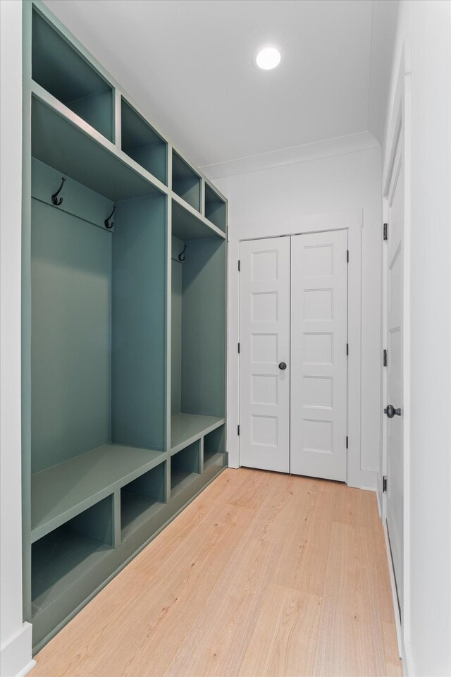 mudroom featuring wood finished floors and crown molding