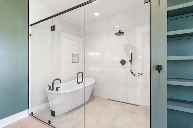 bathroom with recessed lighting, a freestanding bath, tile walls, and a shower stall