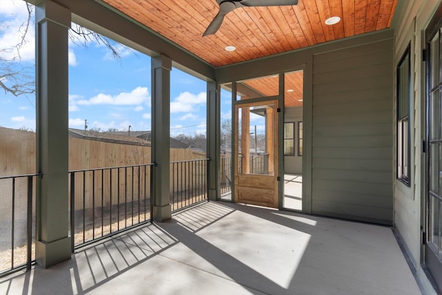 unfurnished sunroom with wooden ceiling, a healthy amount of sunlight, and ceiling fan