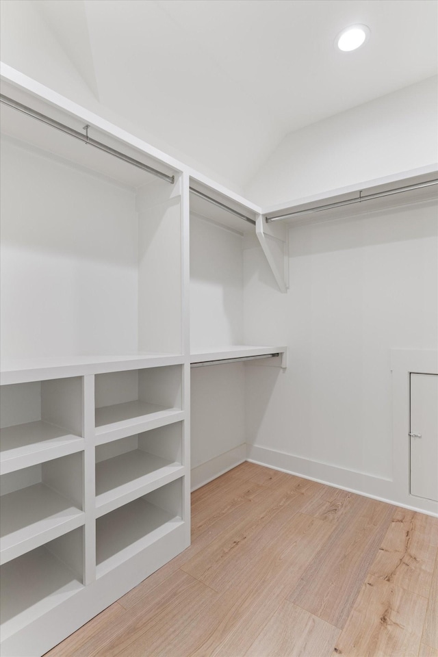 walk in closet with lofted ceiling and wood finished floors