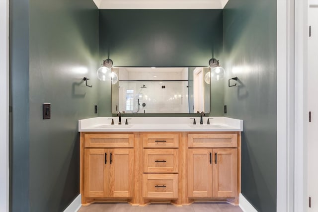 bathroom featuring double vanity, baseboards, a stall shower, and a sink