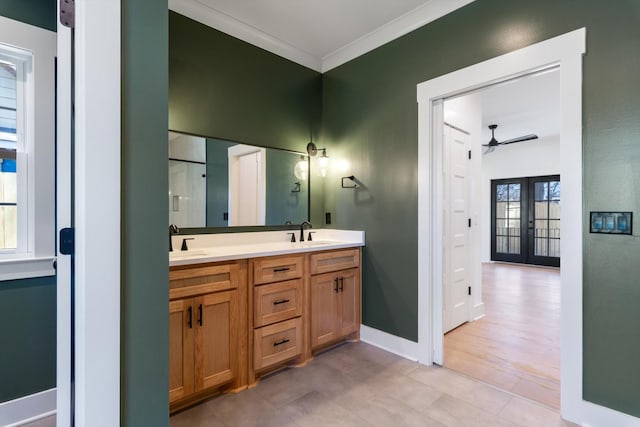 bathroom featuring a sink, french doors, ornamental molding, and double vanity