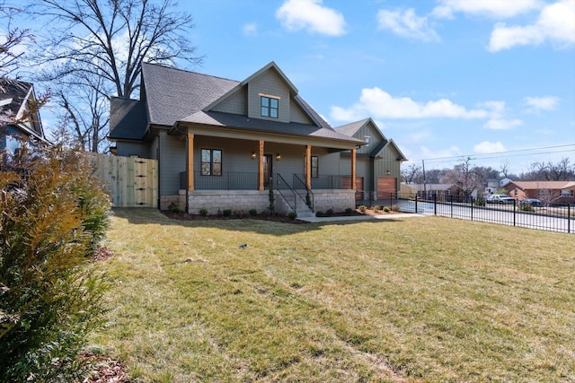 view of front of house with a gate, fence, a porch, a front lawn, and stone siding