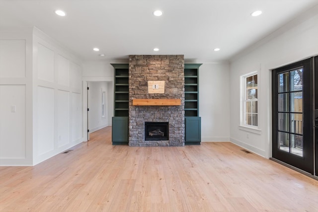 unfurnished living room featuring built in features, light wood-type flooring, recessed lighting, and a fireplace