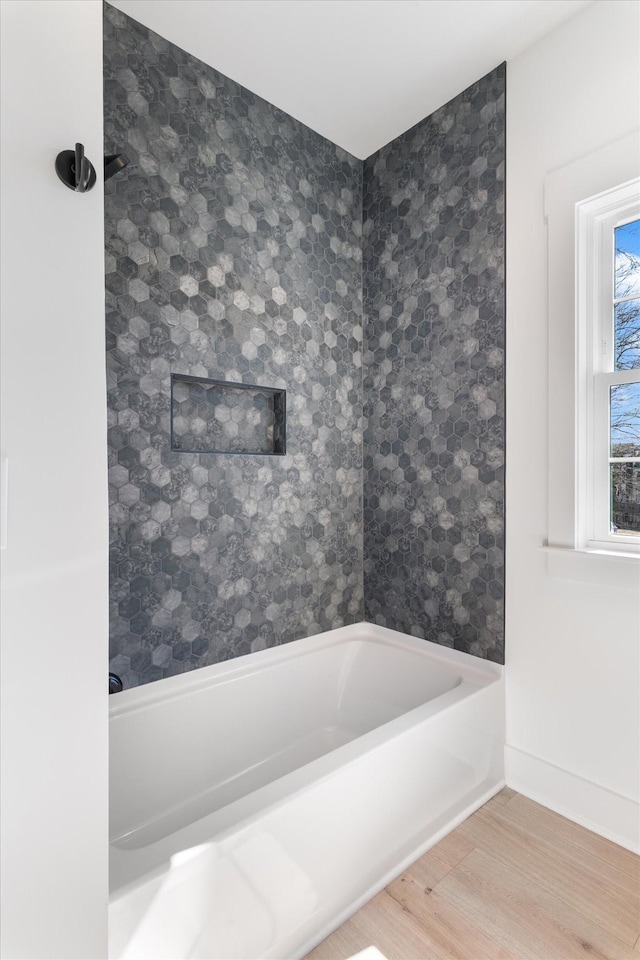 bathroom with shower / bathtub combination, baseboards, and wood finished floors