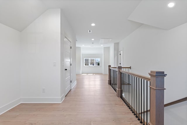 hall with recessed lighting, light wood-type flooring, baseboards, and an upstairs landing