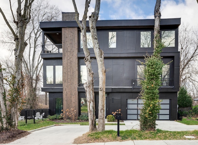 view of front of home featuring a garage and a balcony