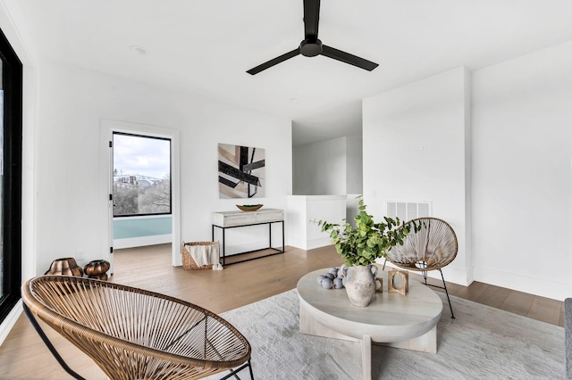 living area featuring hardwood / wood-style flooring and ceiling fan