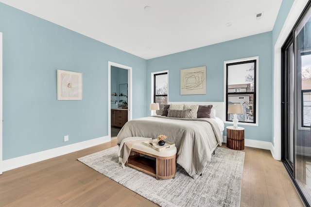 bedroom featuring light hardwood / wood-style floors and connected bathroom