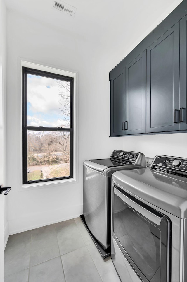 washroom with cabinets, light tile patterned flooring, and washing machine and dryer