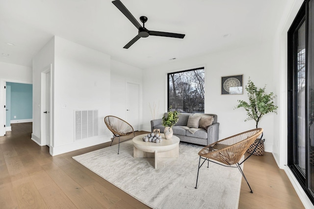 living room featuring hardwood / wood-style floors and ceiling fan