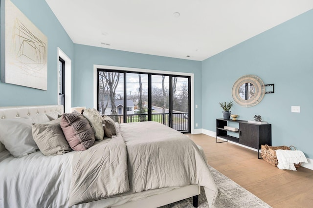 bedroom featuring access to exterior and light hardwood / wood-style flooring