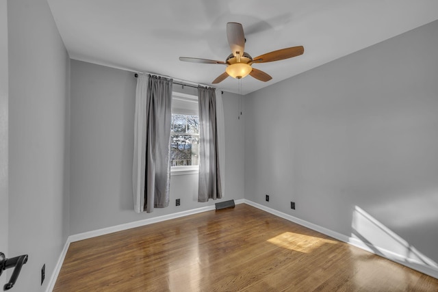 empty room with ceiling fan and hardwood / wood-style floors