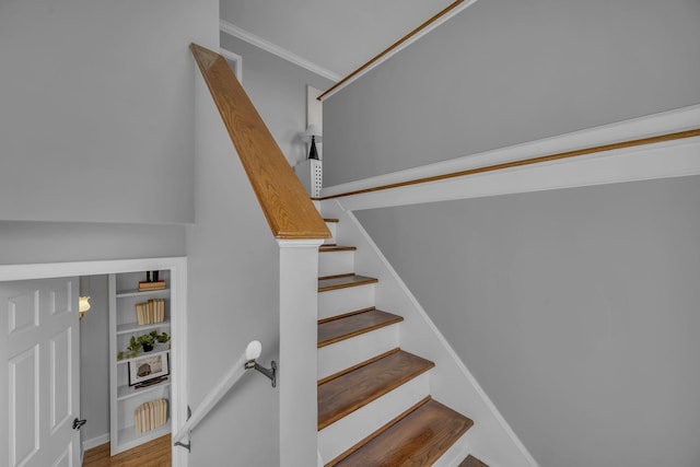 stairs with built in features and hardwood / wood-style floors