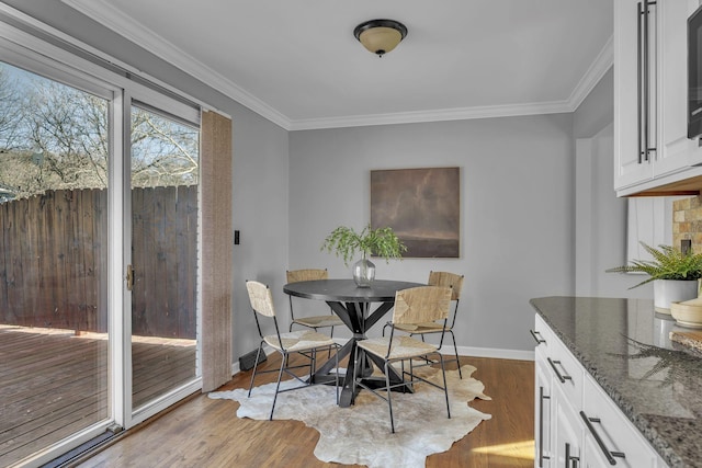 dining room featuring light hardwood / wood-style flooring and ornamental molding