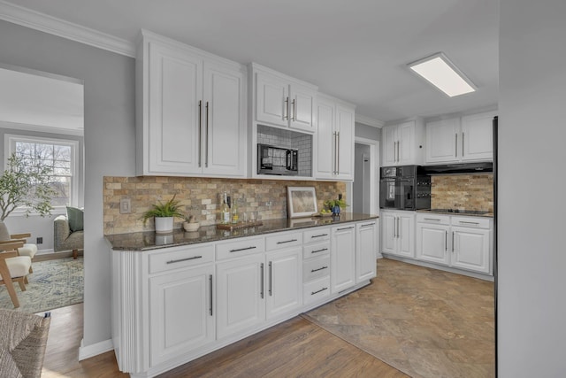 kitchen featuring black appliances, hardwood / wood-style flooring, decorative backsplash, white cabinets, and dark stone counters