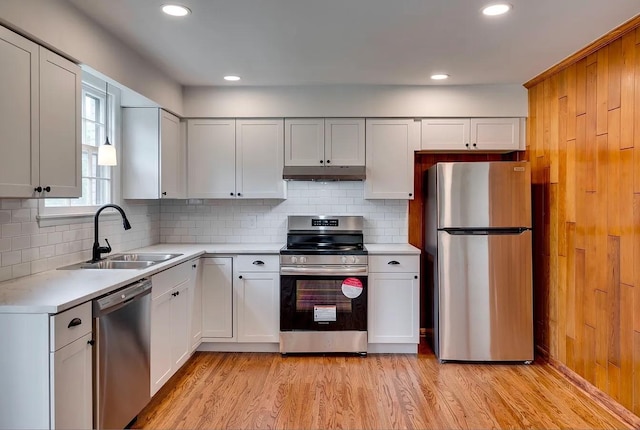 kitchen featuring white cabinetry, sink, stainless steel appliances, tasteful backsplash, and light hardwood / wood-style floors