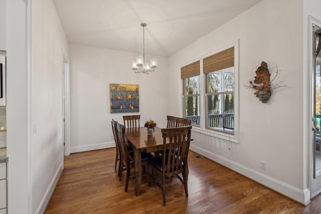 dining area featuring dark hardwood / wood-style floors and a chandelier