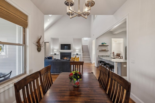 dining room with an inviting chandelier, dark hardwood / wood-style floors, and vaulted ceiling