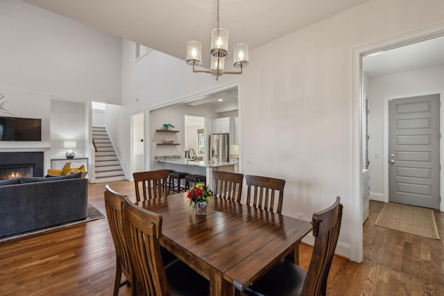 dining area with dark hardwood / wood-style floors, sink, and a notable chandelier