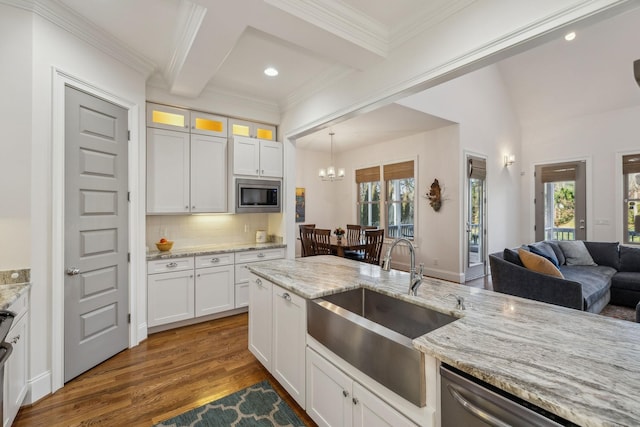 kitchen with backsplash, stainless steel appliances, sink, and white cabinets