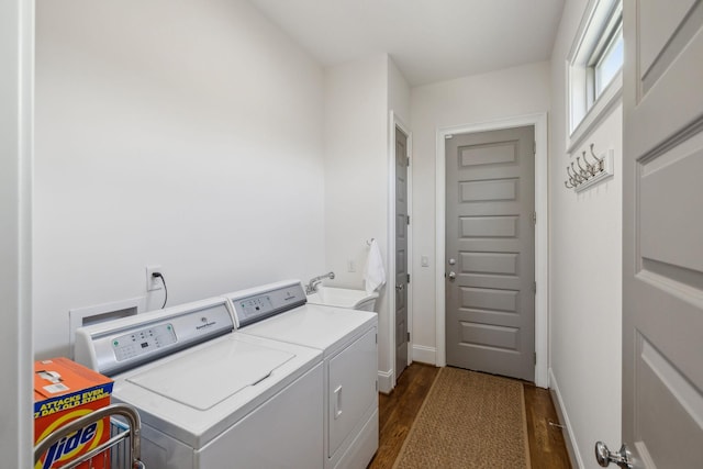 laundry area featuring washer and dryer, sink, and dark hardwood / wood-style floors